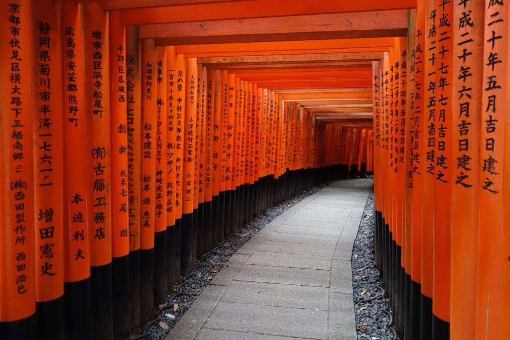 A tunnel of vermilion torii gates along the Senbon Torii path at Fushimi Inari Shrine in Kyoto