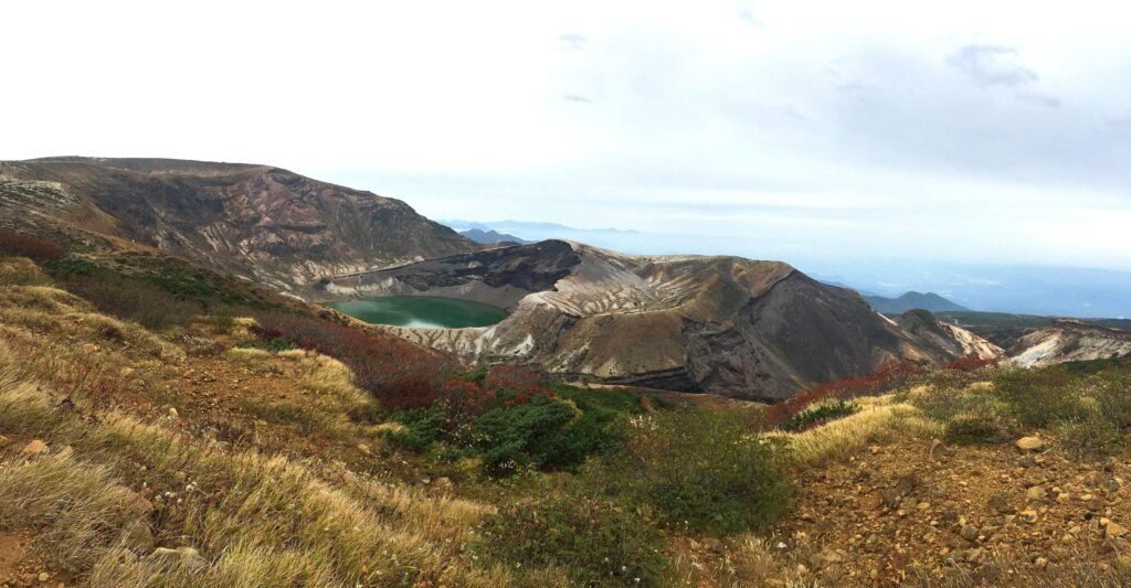 Okama crater lake on Mount Zao surrounded by autumn foliage